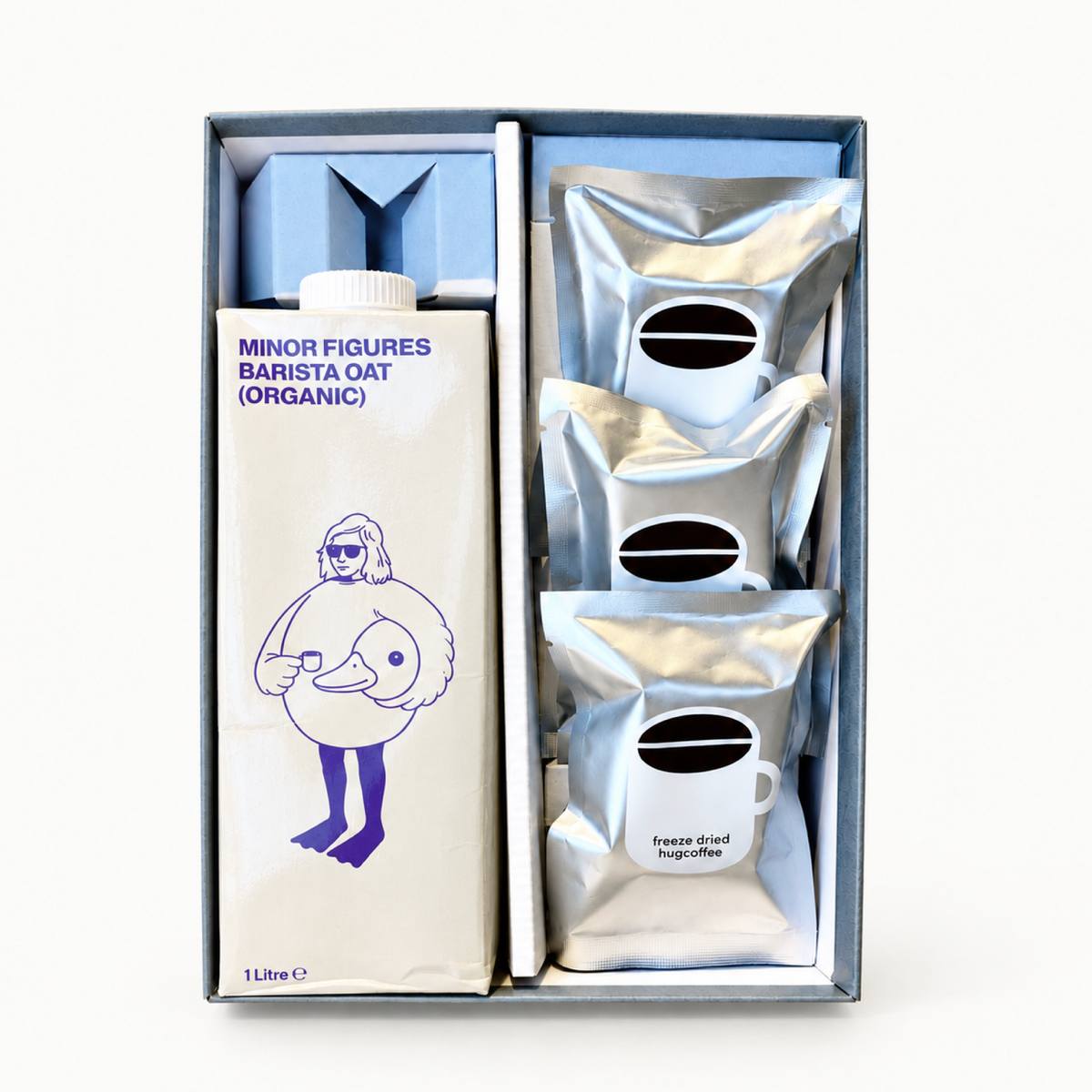 hugcoffeeのフリーズドライコーヒーとオーツミルクのギフトセット。箱に入った銀色の袋と紙パック。